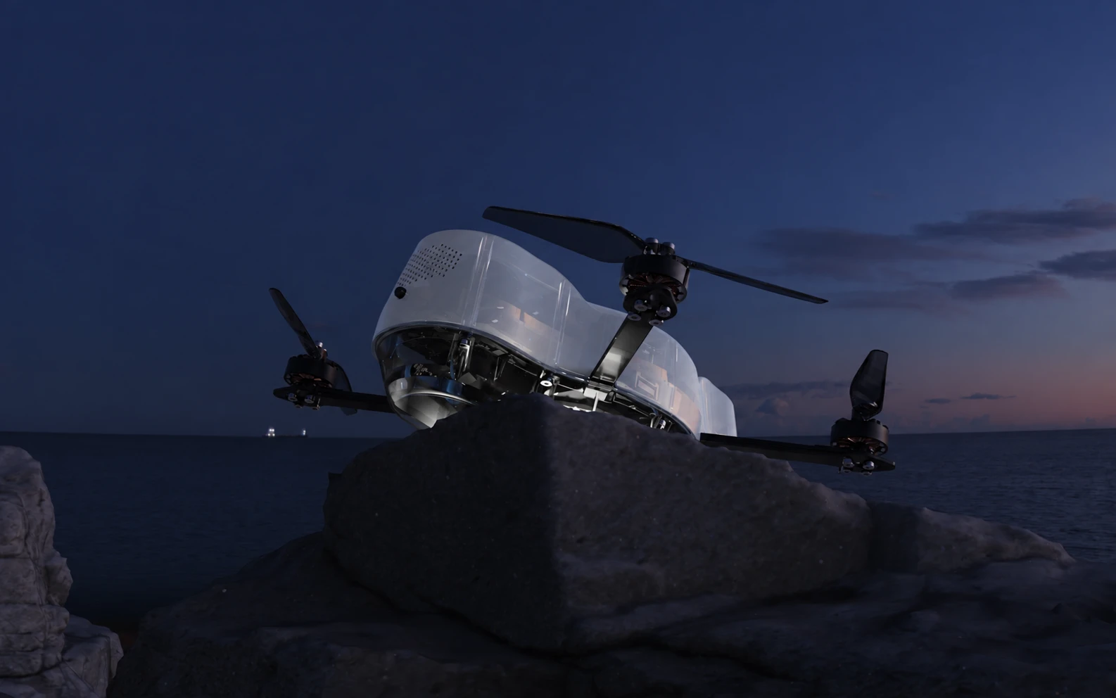 Starbound Spectra drone resting on a rock beside the sea at dusk
